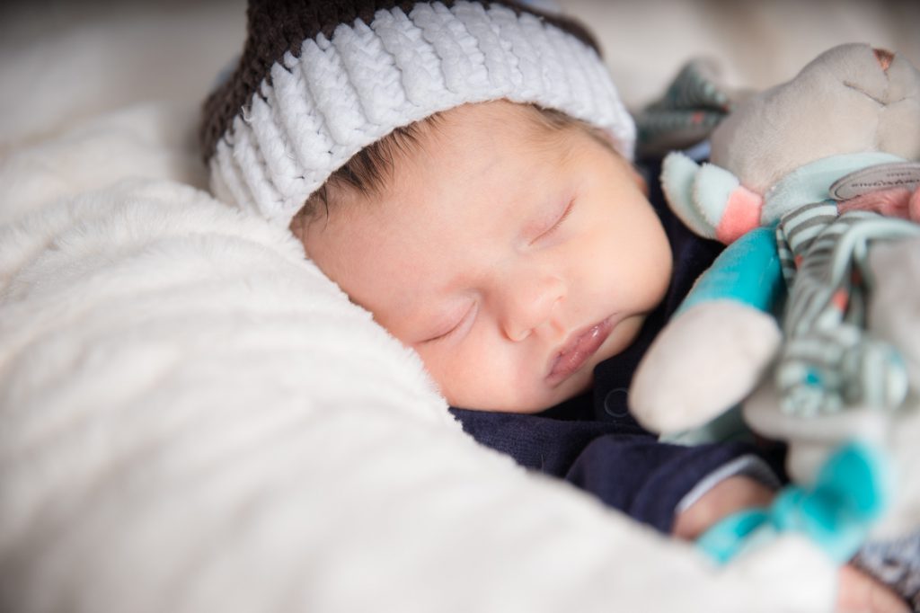 Bébé ,avec son doudou dans les bras , endormi. Photo Studio Polidori