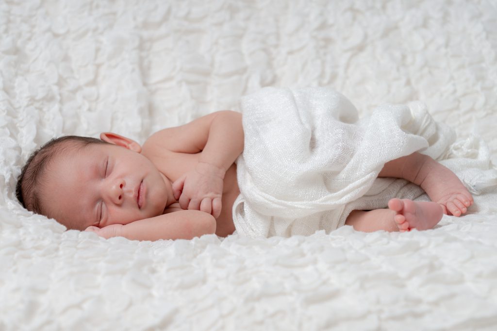 Bébé dormant sur le côté, tête posée sur son épaule. Photo Studio Polidori