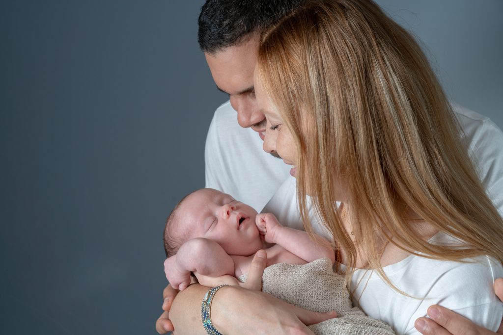 Maman et papa regardent bébé endormi. Photo Studio Polidori