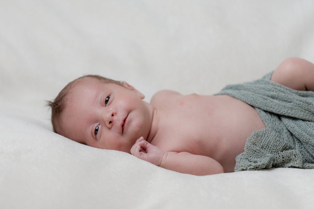 Bébé petite sourire, yeux ouverts. Photo Studio Polidori