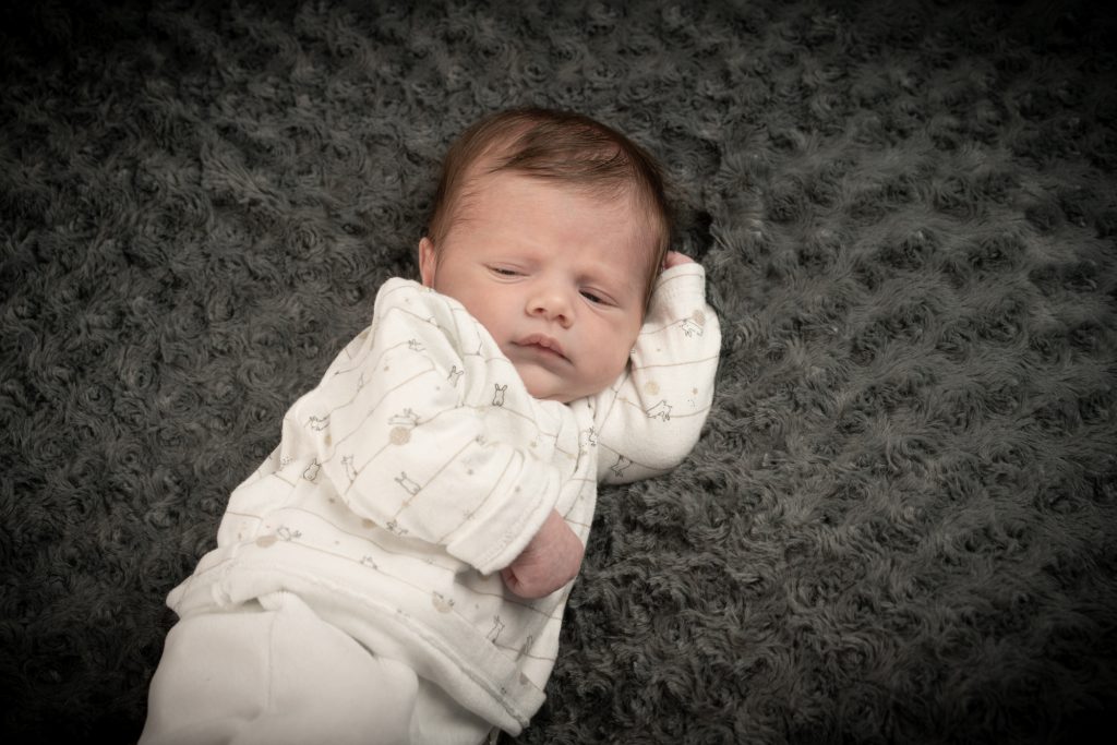 Bébé se posant, la tête appuyée au creux de son coude. Photo Studio Polidori