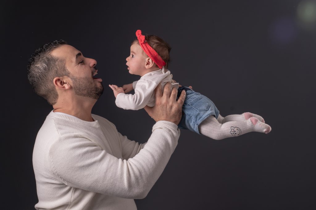 Papa fait voler bébé dans ses bras, Regard entre les 2. Photo Studio Polidori