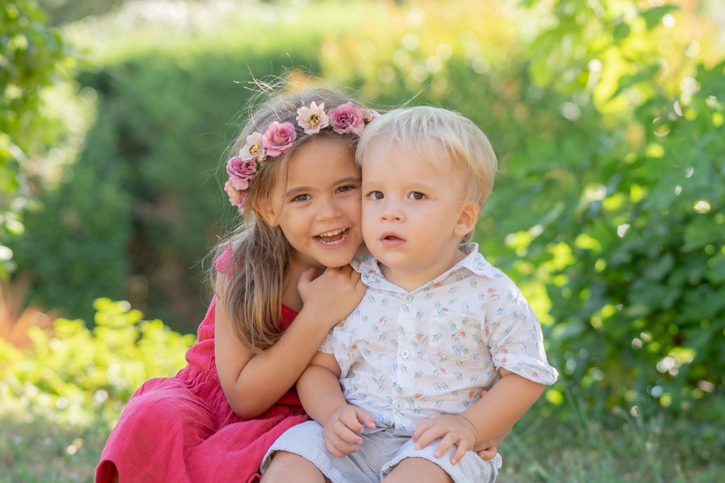 La soeur dévoile un secret à son petit frère, moment de tendre complicité dans la nature. Photo Studio Polidori