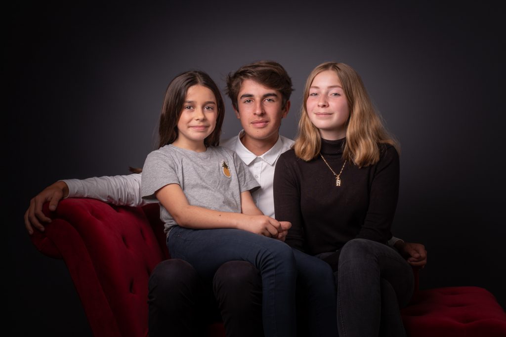 Le grand frère est entouré de ses 2 soeurs. Photo Studio Polidori