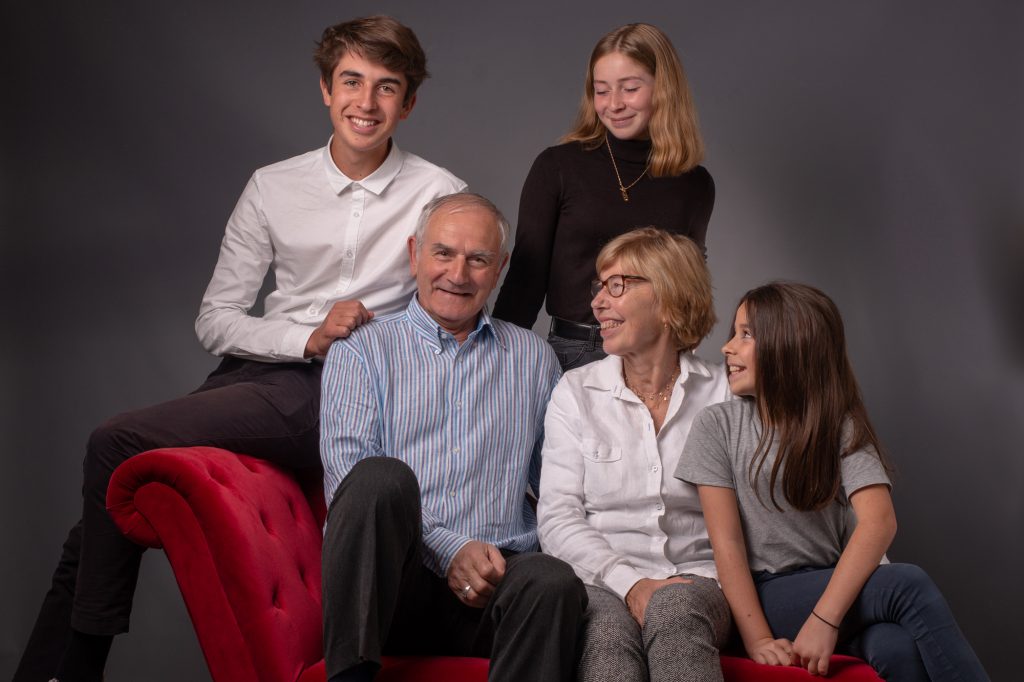 Les grand-parents sont entourés de leurs petits enfants. Regard vers papy. Photo Studio Polido