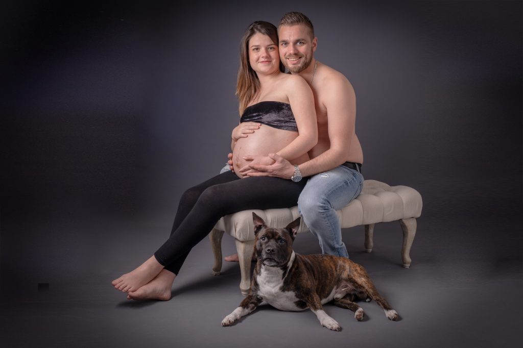 Un jeune couple avec madame enceinte assis, leur chien à leurs pieds. Photo Studio Polidori