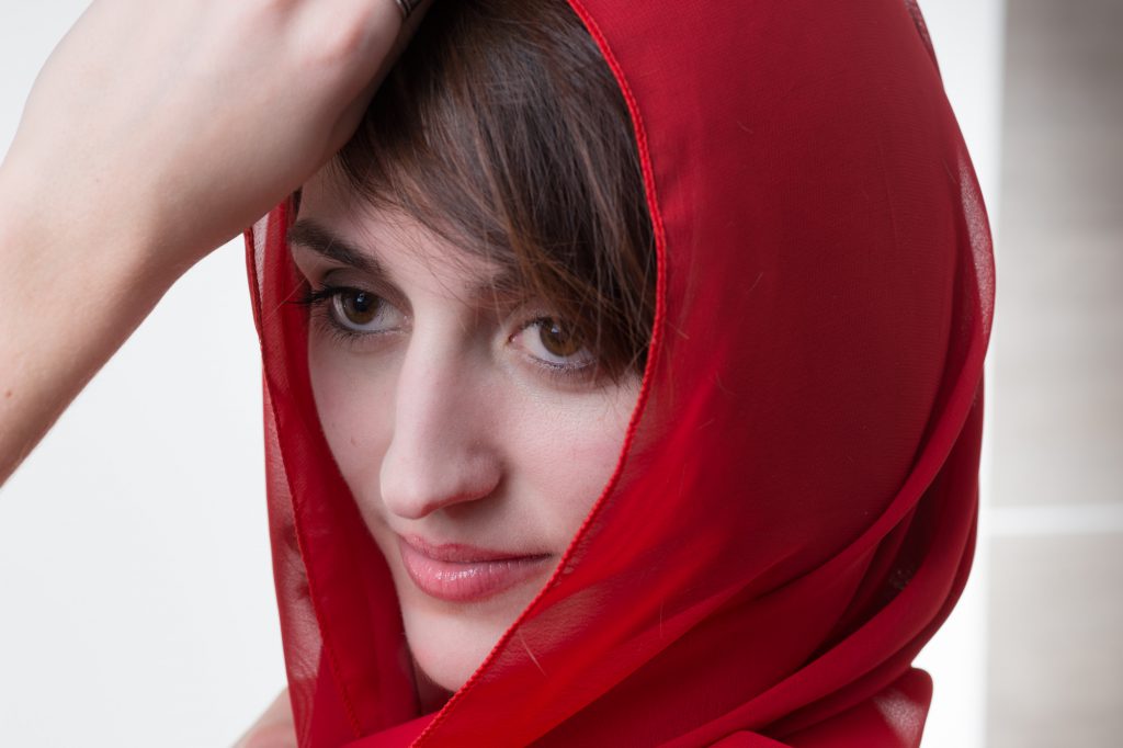 Portrait d'une femme sur fond blanc, avec foulard rouge. Photo Studio Polidori