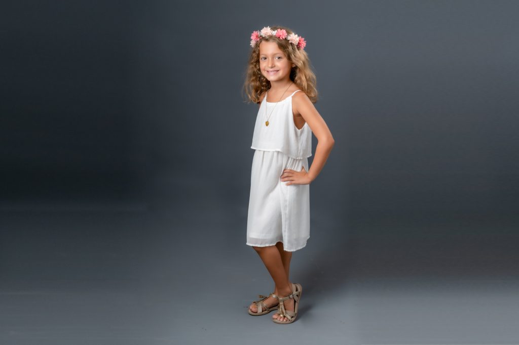 Une jeune fille avec une couronne de fleur pose au studio. Studio Polidori