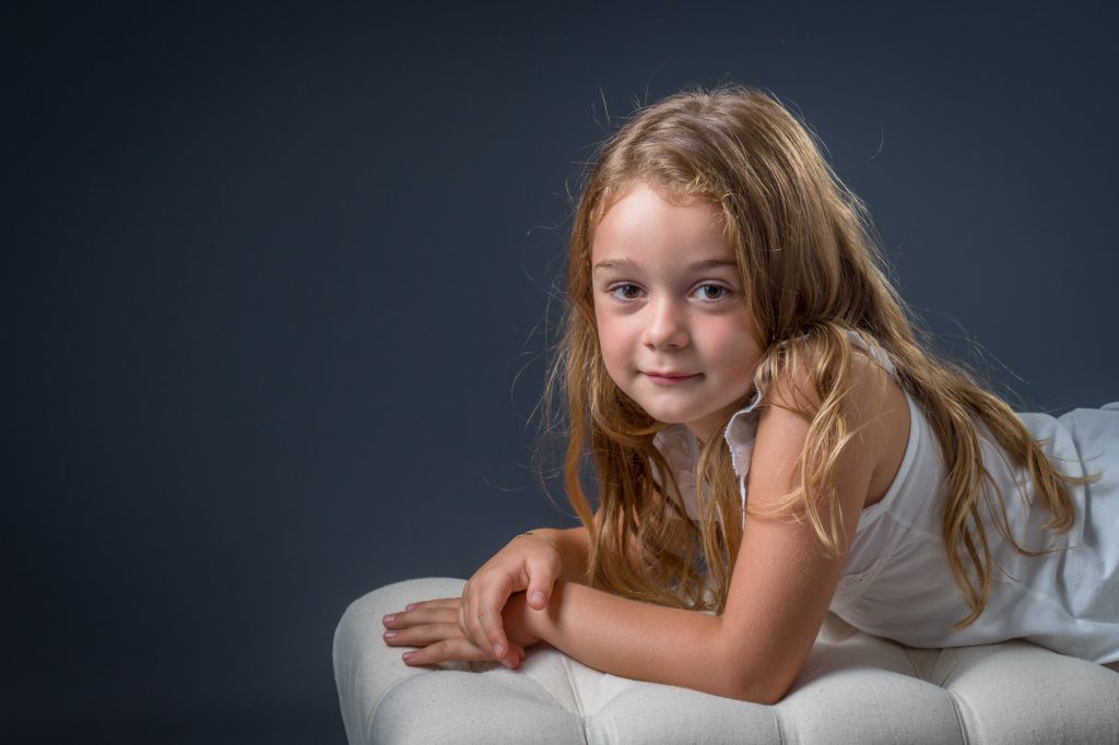 Au studio, une jeune fille pose sur un banc. Photo Studio Polidori