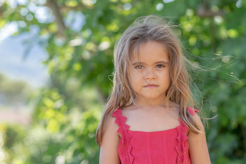 Une jeune fille, l'air un peu boudeur, à l'extérieur. Photo Studio Polidori