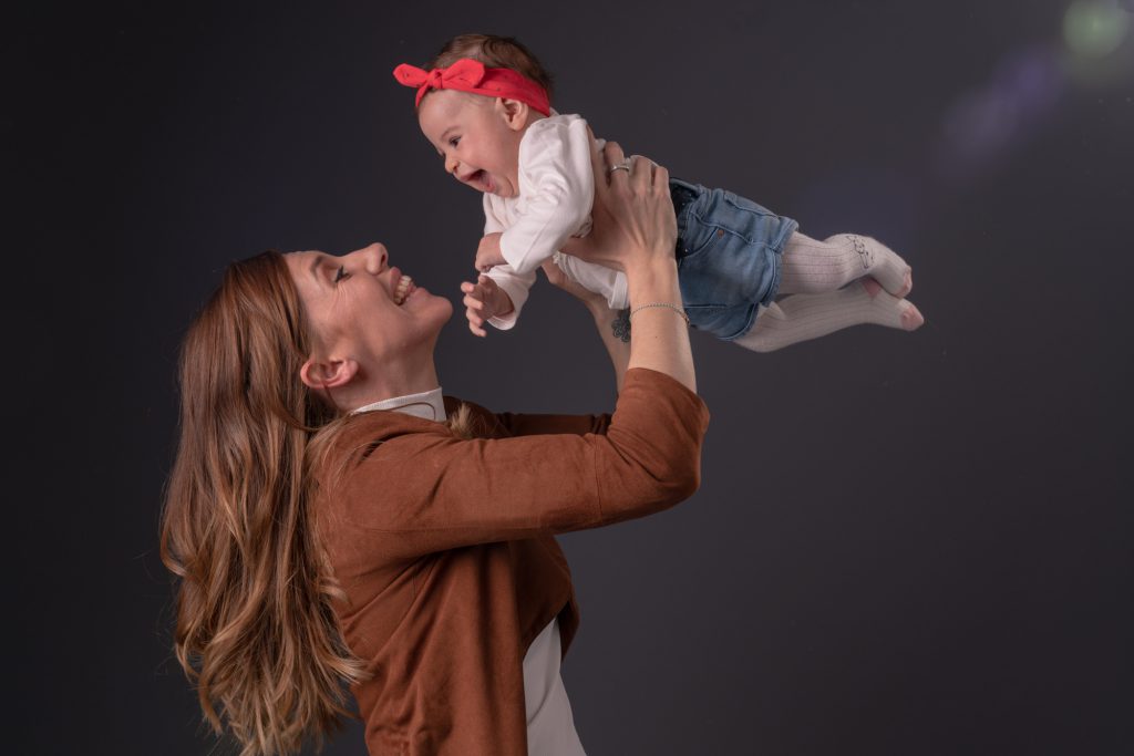 Maman s'éclate avec sa petite fille en la faisant voler. Enorme sourire et rire des 2. Photo Studio Polidori