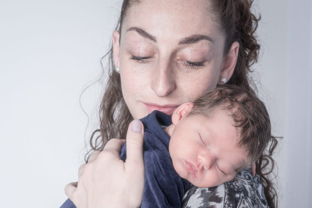 Regard tendre d'une maman sur son bébé, endormi sur son épaule. Photo Studio Polidori