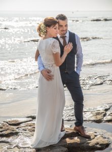 Couple de mariés posant sur les rochers au bord de l'eau, plage de Boulouris. Photo Studio Polidori