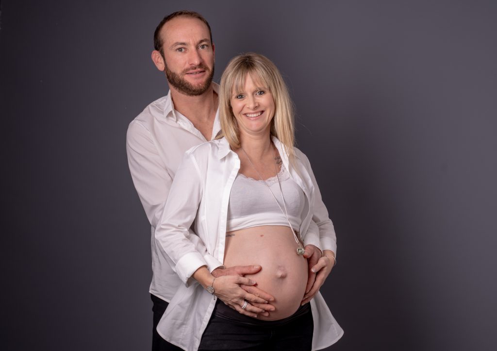 Papa et future maman se tenant les mains sur le ventre rond. Photo Studio Polidori